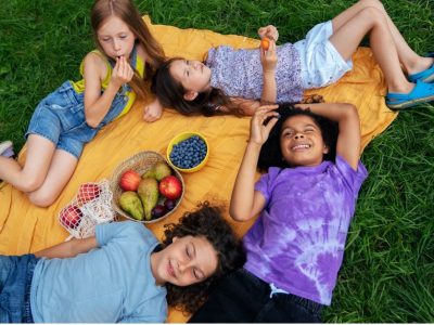 Деца от лагера Лъки Кидс ядат плодове по време на пикник.